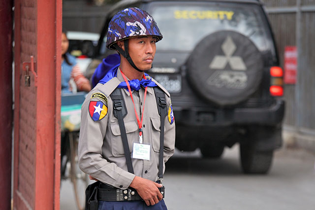 Photo: Vladimir Melnik / Shutterstock. Myanmar police – special security force on duty at the entrance of the Royal Palace of Mandalay.